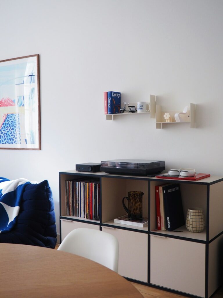 A room with a bed, a table, and a record player